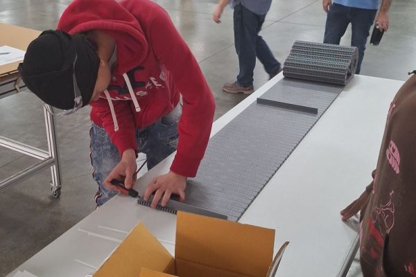 Student works hands on with conveyor belt assembly